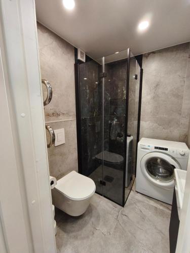 Un baño con inodoro y lavadora. en 'Design korter Kehras', en Kekra