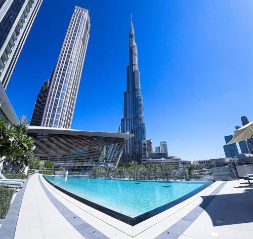 a swimming pool in front of a city skyline at GRANDE RESIDENCES with a direct Burj Khalifa view and Private Fountain Show at 31st floor with DXB AIRPORT VIP Shuttle in Dubai