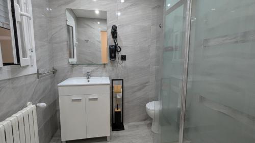 a bathroom with a toilet and a sink and a shower at Casa Clari in Motilla del Palancar