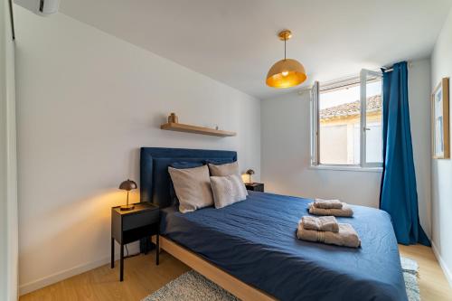 une chambre avec un lit bleu et une fenêtre dans l'établissement Raffinement Romain Cœur de Nimes Lumineux, à Nîmes