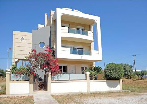 a white building with flowers in front of it at Katia's House in Ampavris