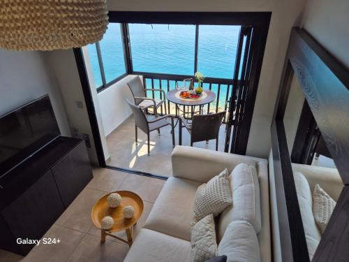 a living room with a couch and a table at Very Romantic Seaview Apartment Patalavaca Mogán with Warm Pool in Patalavaca