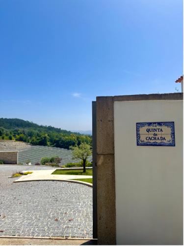 a sign on a wall next to a driveway at Quinta da Cachada in Moure