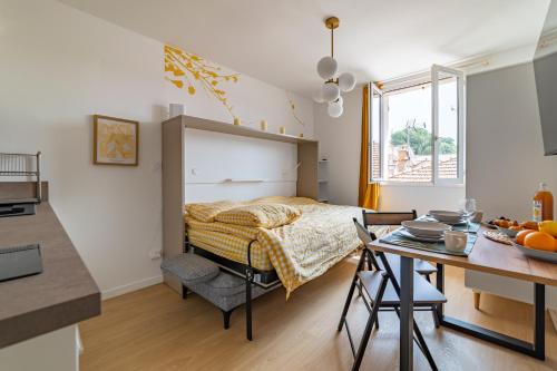- une chambre avec un lit et une table avec une cuisine dans l'établissement Golden Studio - View & Provençal Charm, à Nîmes