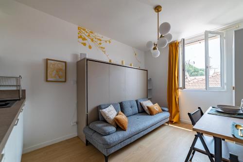 un salon avec un canapé bleu et une table dans l'établissement Golden Studio - View & Provençal Charm, à Nîmes