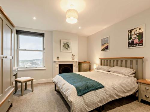 1 dormitorio con 1 cama, chimenea y ventana en 2 Bed in Woolacombe 90798, en Mortehoe