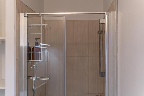 une douche avec une porte vitrée dans une salle de bain dans l'établissement Golden Studio - View & Provençal Charm, à Nîmes