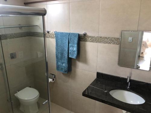 a bathroom with a sink and a toilet and a mirror at Casa espaçosa - 3 quartos - Caçari in Boa Vista