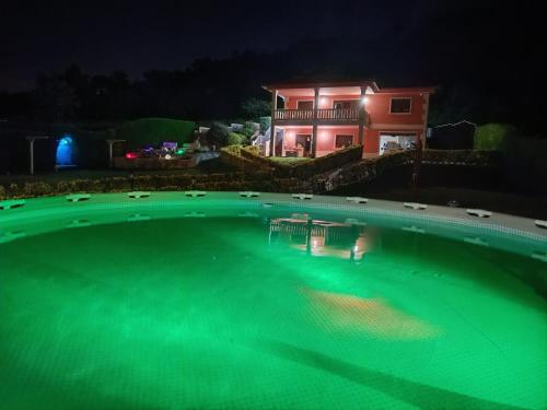 una piscina por la noche con una casa en el fondo en Oasis Inn Pedornes, en Pedornes