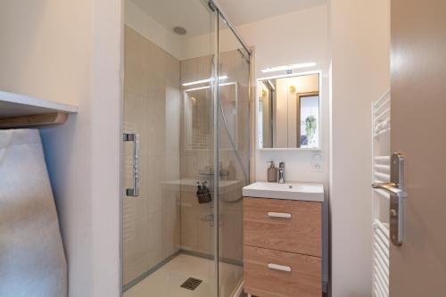 une salle de bain avec une douche en verre et un lavabo dans l'établissement La Forêt Vierge - Nature Refuge, à Nîmes
