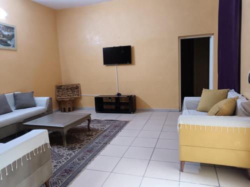 a living room with two couches and a tv at Résidence Loued in Tozeur