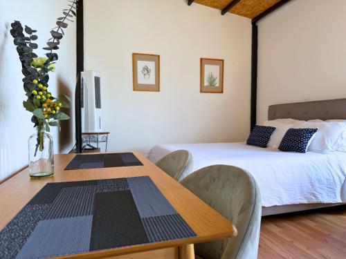 ein Schlafzimmer mit einem Bett und einem Tisch mit Stühlen in der Unterkunft Your Cozy Corner in Oaxaca with AC in Oaxaca de Juárez