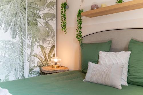 - une chambre avec un lit vert et une lampe sur une table dans l'établissement La Forêt Vierge - Nature Refuge, à Nîmes