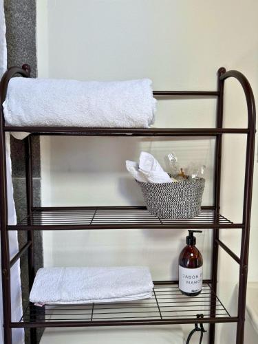 a towel rack with towels and a basket of towels at Your Cozy Corner in Oaxaca with AC in Oaxaca City