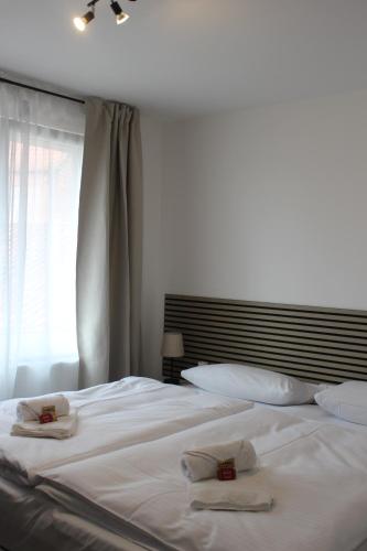 a white bed with two towels on top of it at Boutique Hotel - Celler Altstadt in Celle