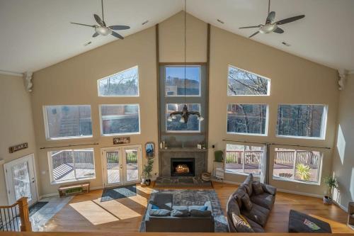 a living room with a fireplace and large windows at Lakeshore Retreat with Lake Lanier views & hot tub in Landrum