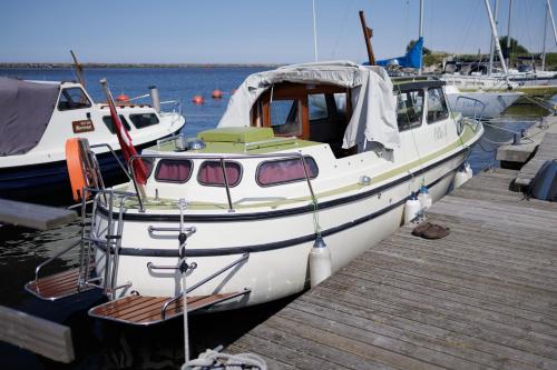 a white boat is docked at a dock at Laiva Engures ostā in Engure