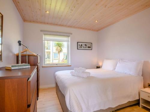 a bedroom with a large white bed and a window at 3 Bed in Hopton 88649 in Fritton Norfolk