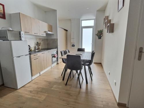 a kitchen and dining room with a table and chairs at Appartement Zen & Cosy in Ambérieu-en-Bugey