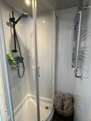 a shower with a glass door in a bathroom at Clovelly Suite Four Poster Bed & Breakfast in Westward Ho