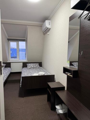 a small room with a bed and a mirror at GT Hotel in Chernivtsi
