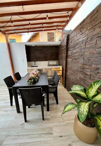 a dining room with a table and chairs and a brick wall at Casa en la playa Costa y Mar 4 in San Jacinto