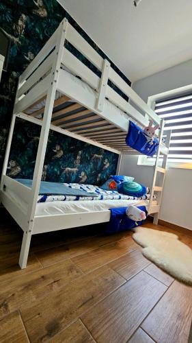 a bedroom with two bunk beds and a ladder at Apartamenty Dana in Pustkowo