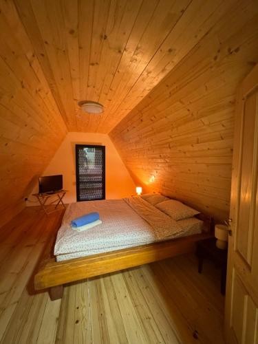 a bedroom with a bed in a wooden cabin at Apartmani Gocki Raj 2024 Vrnjačka Banja in Vrnjačka Banja