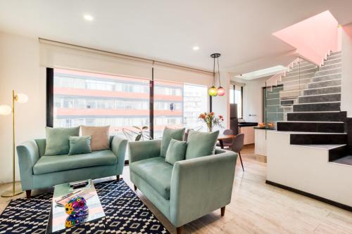 een woonkamer met twee stoelen en een trap bij MEDELLIN by Mr W in Mexico-Stad