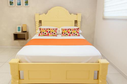 a bedroom with a yellow bed with two pillows at Taybo House by St Hoteles in San Andrés
