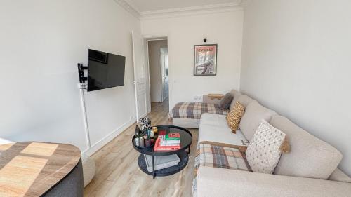un salon avec un canapé et une table dans l'établissement Neuilly Étoilé - 2 Personnes - Luxe Proche Métro - Direct Paris, à Neuilly-sur-Seine