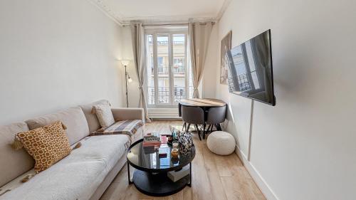 un salon avec un canapé et une table dans l'établissement Neuilly Étoilé - 2 Personnes - Luxe Proche Métro - Direct Paris, à Neuilly-sur-Seine