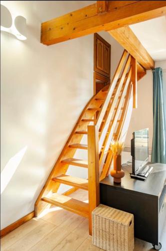 - un escalier en bois dans une chambre avec un bureau dans l'établissement Magnifique Appartement traversant avec vue sur le golf, à La Grande Motte