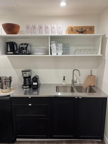 a kitchen with a sink and a counter top at The Kent Motel in Niagara on the Lake