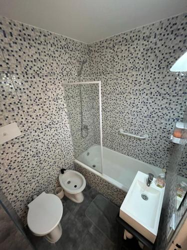 a bathroom with a toilet and a tub and a sink at Hermoso, con vista al obelisco in Buenos Aires