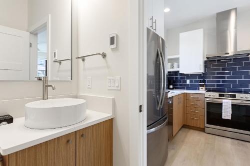 a white kitchen with a sink and a refrigerator at Hamilton Place Bayside Building 301 B in Traverse City