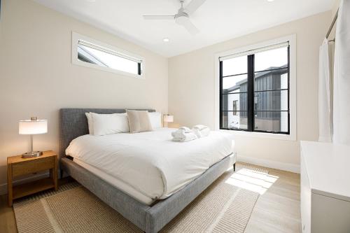 a white bedroom with a bed and a window at Hamilton Place Bayside Building 301 B in Traverse City