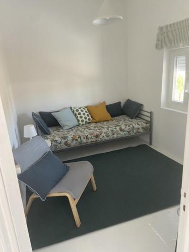 a living room with a couch and a chair at Casinha da praia in Costa de Santo André