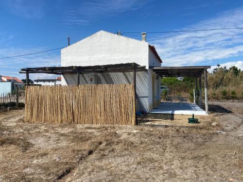 a house with a wooden fence in front of it at Casinha da praia in Costa de Santo André