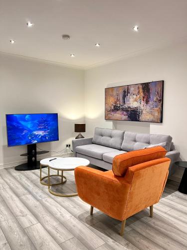 a living room with a couch and a tv at Luxury home in prime location Steps from WoodGreen in London