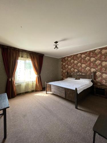 a bedroom with a large bed and a window at GT Hotel in Chernivtsi