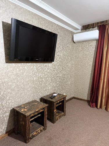a room with two tables and a flat screen tv at GT Hotel in Chernivtsi