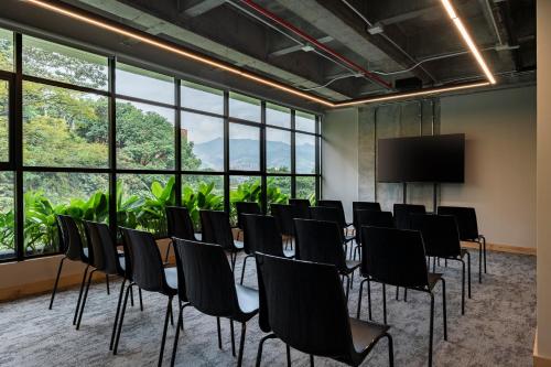 a conference room with chairs and a projection screen at Faranda Collection Medellin, a Member of Radisson Individuals in Medellín