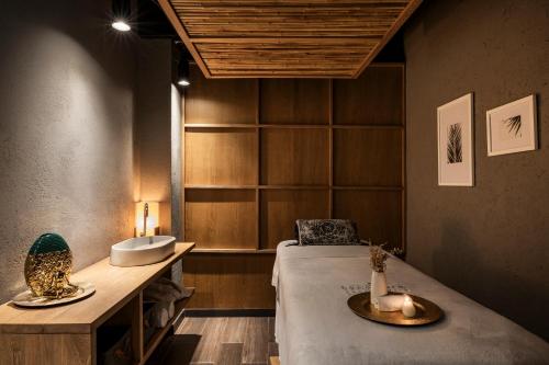 a room with a bed and a sink and a table at Faranda Collection Medellin, a Member of Radisson Individuals in Medellín