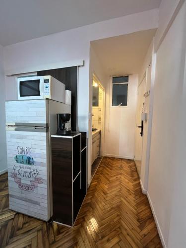 a small kitchen with a refrigerator and a microwave at Quinto piso a la calle, cómodo, equipado, luminoso y bien ubicado in Buenos Aires