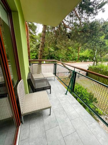 ein Balkon mit zwei Stühlen und einem Tisch in der Unterkunft Apartament w Zielonym Domu in Jurata
