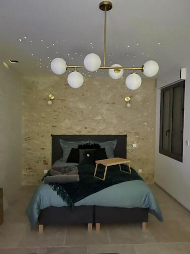 - une chambre avec un lit noir et un lustre dans l'établissement L'indiscrete Loveroom, à Saint-Cyr-sur-Loire