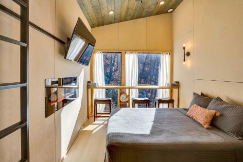 a bedroom with a bed in a tiny house at The Atlas Cedar Treehouse at Treetop Escapes in Wildwood