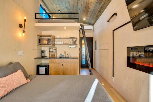 a tiny house with a bed and a kitchen at The Atlas Cedar Treehouse at Treetop Escapes in Wildwood