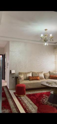 a living room with a couch and a chandelier at Appartement meublé en location nuitée in El Jadida